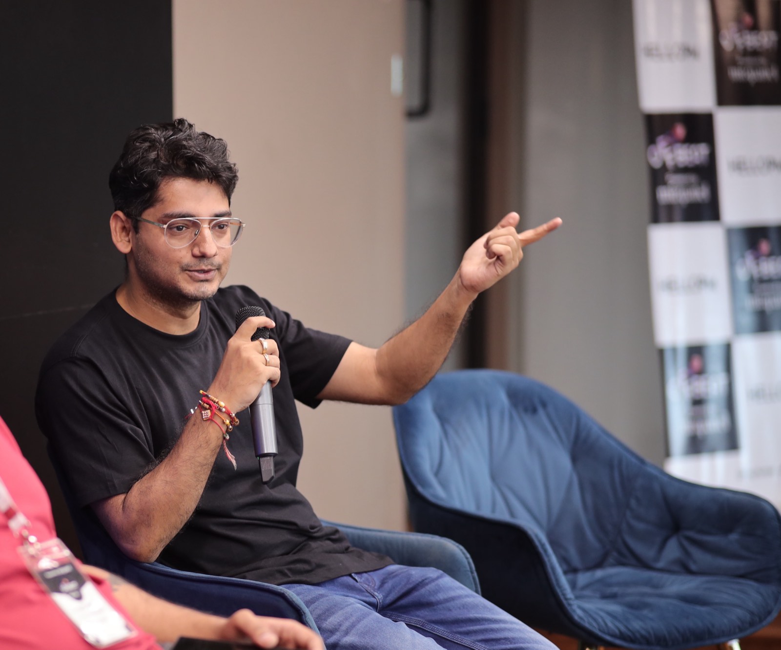 A speaker gesturing with a mic during an Offbeat by HelloPM panel