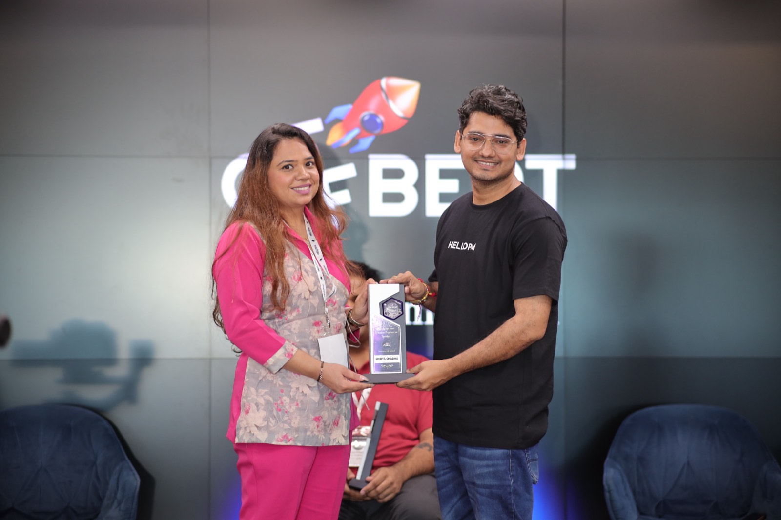 A HelloPM host handing a speaker appreciation award to a panelist at Offbeat