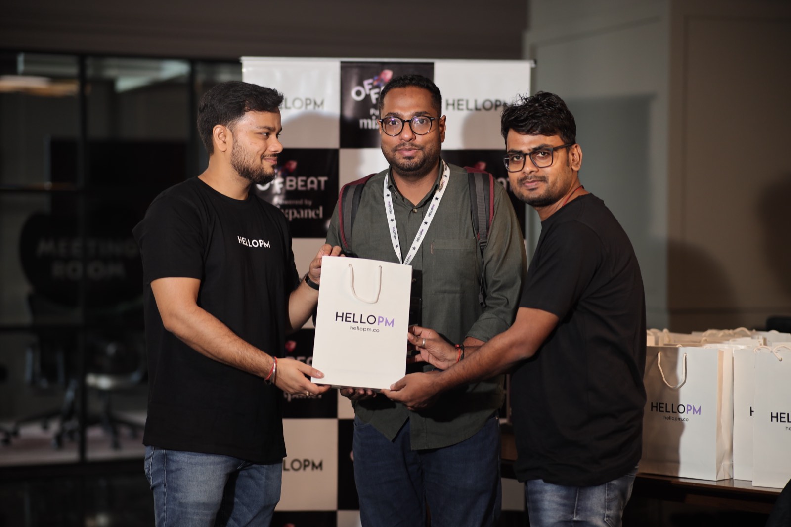 HelloPM organisers handing a branded gift bag to a member at an Offbeat event