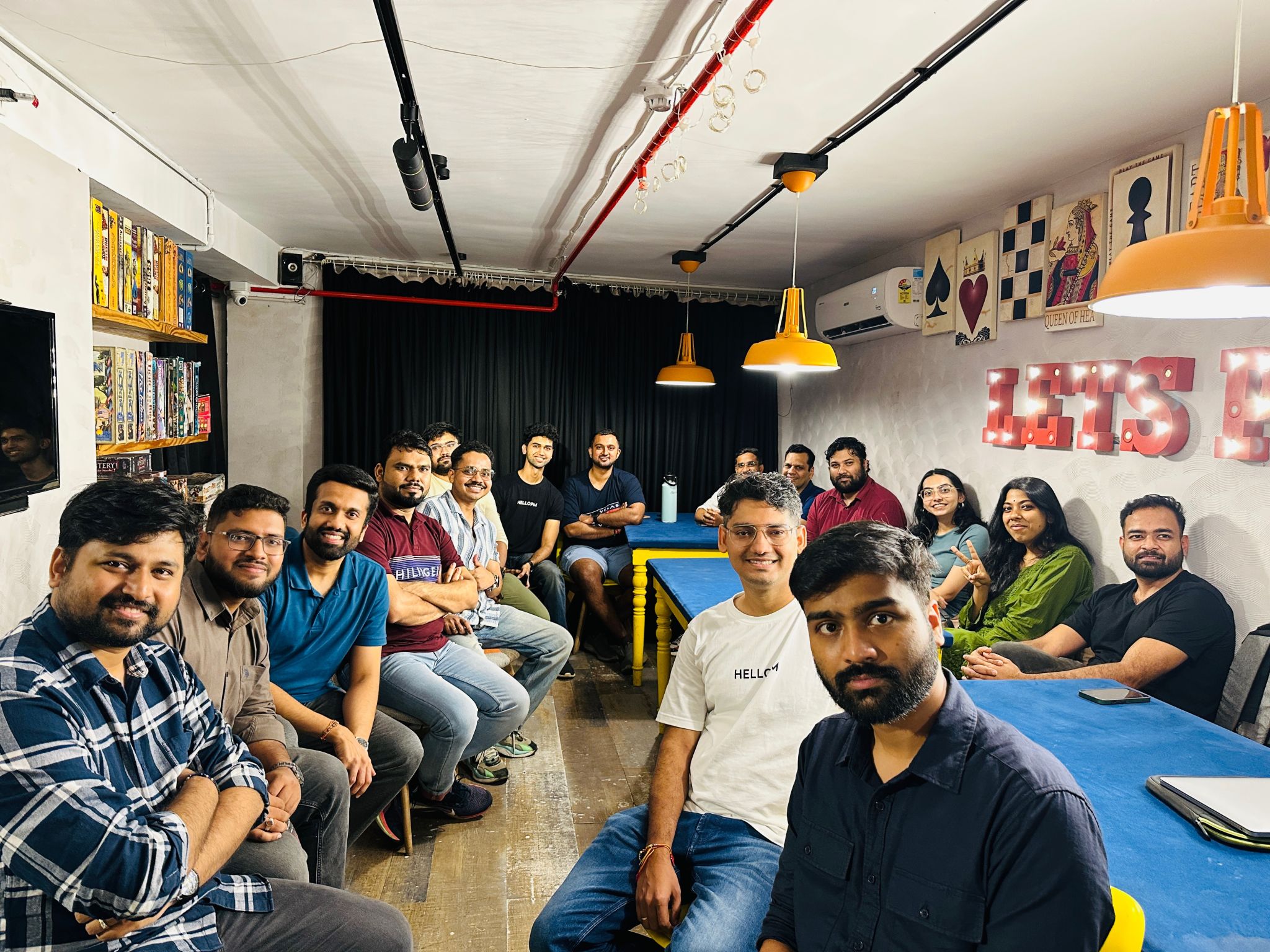 HelloPM members at a board-game cafe with a 'Lets Play' sign