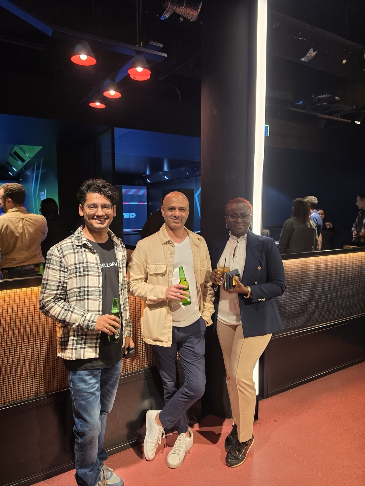Three HelloPM members with drinks at an evening networking meetup in London