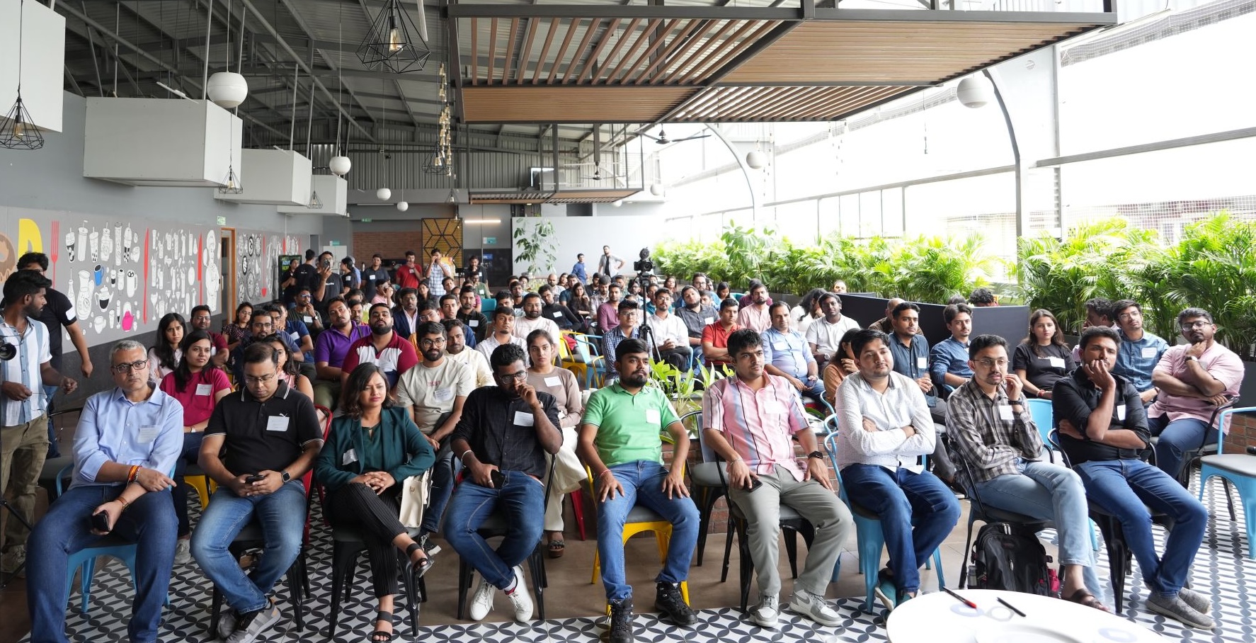 A large HelloPM audience seated at a rooftop venue in Bengaluru