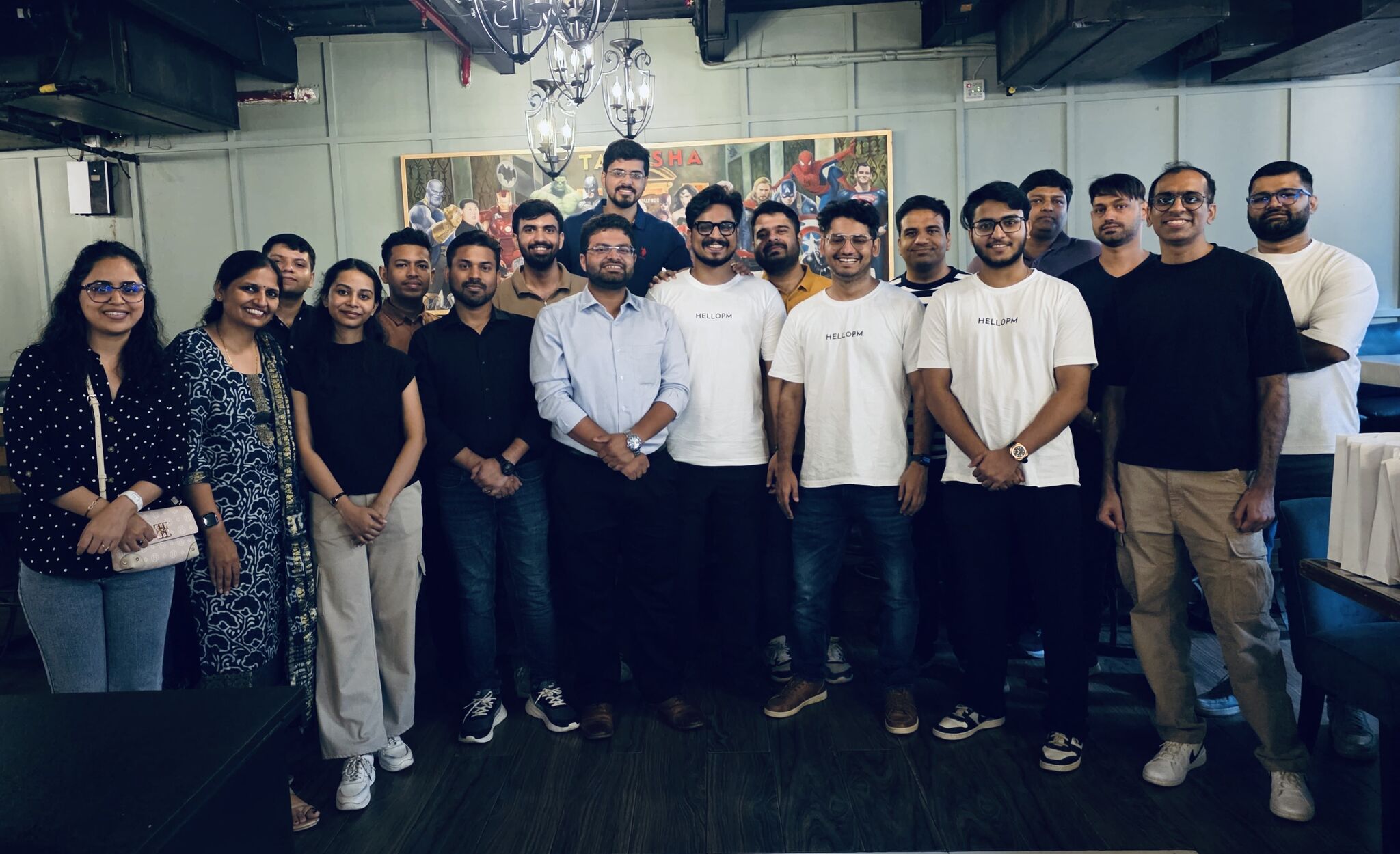 HelloPM members gathered indoors in Delhi in front of a superhero mural
