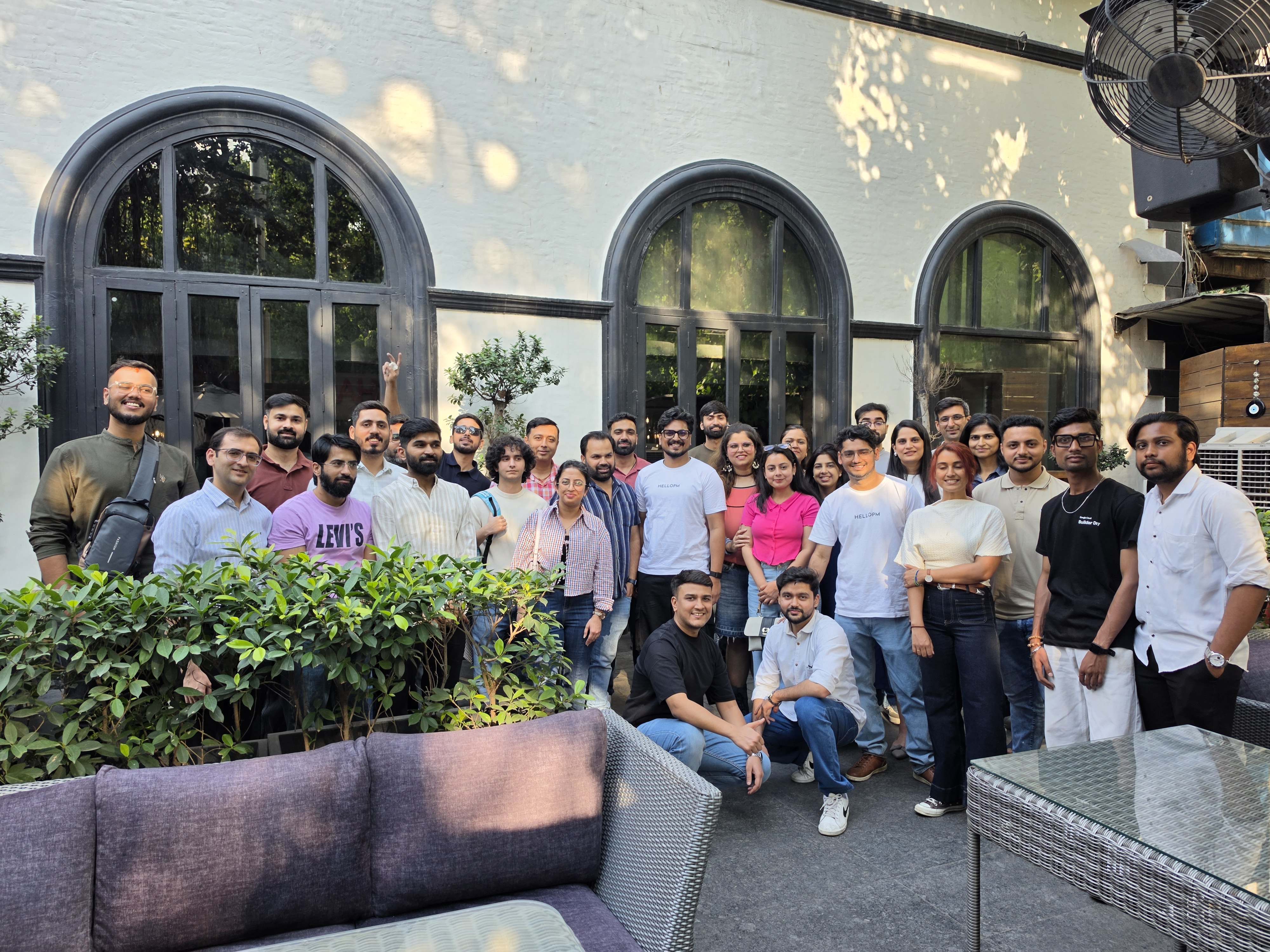 HelloPM Builder Day group photo in a New Delhi courtyard with arched windows
